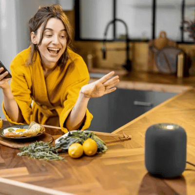 Woman using a voice-activate assistant in her kitchen